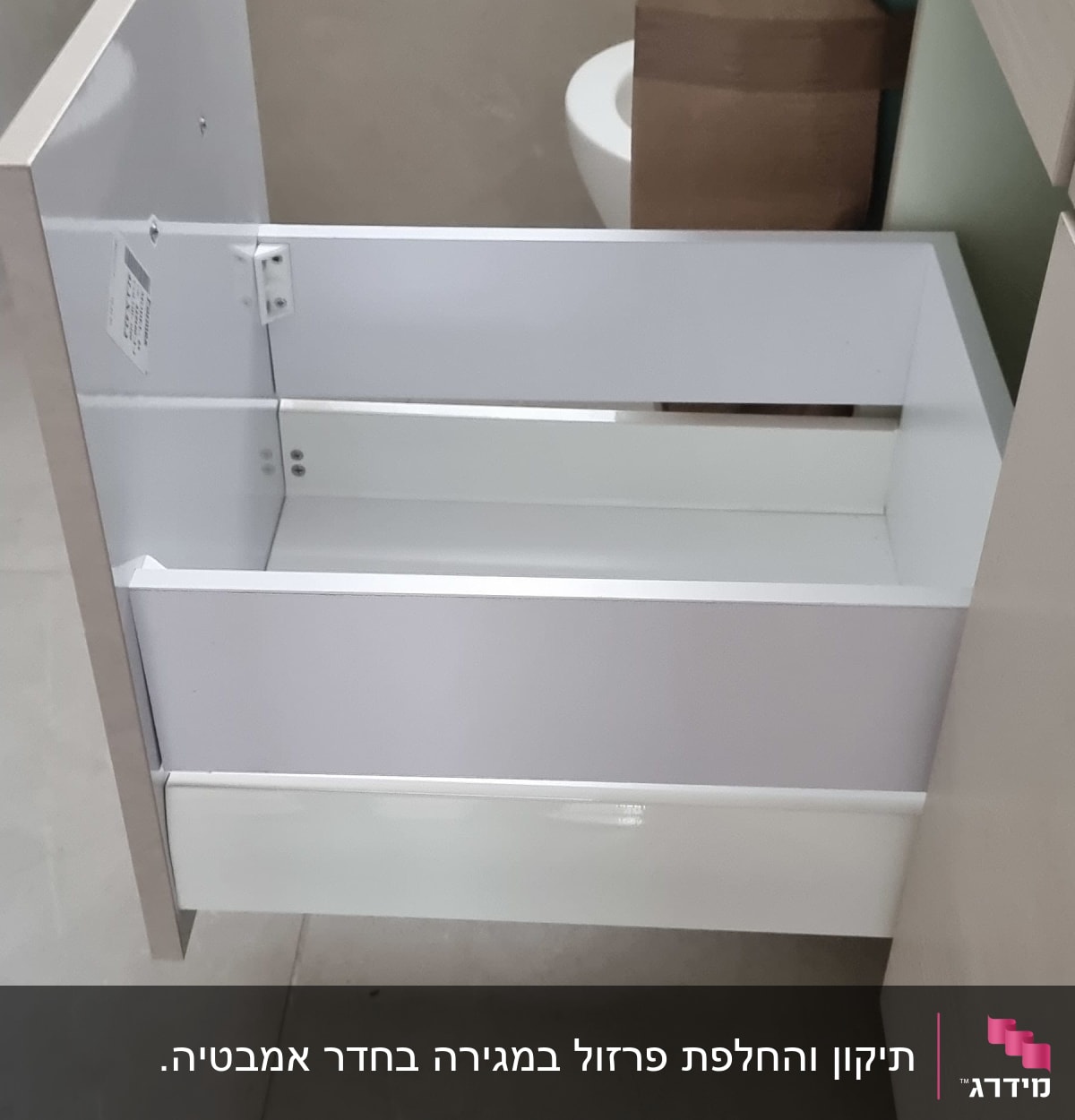 מגירה פתוחה עם מסגרת לבנה וחלקי מתכת